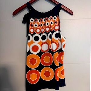 Crewneck, sleeveless blue shirt with orange and white circles